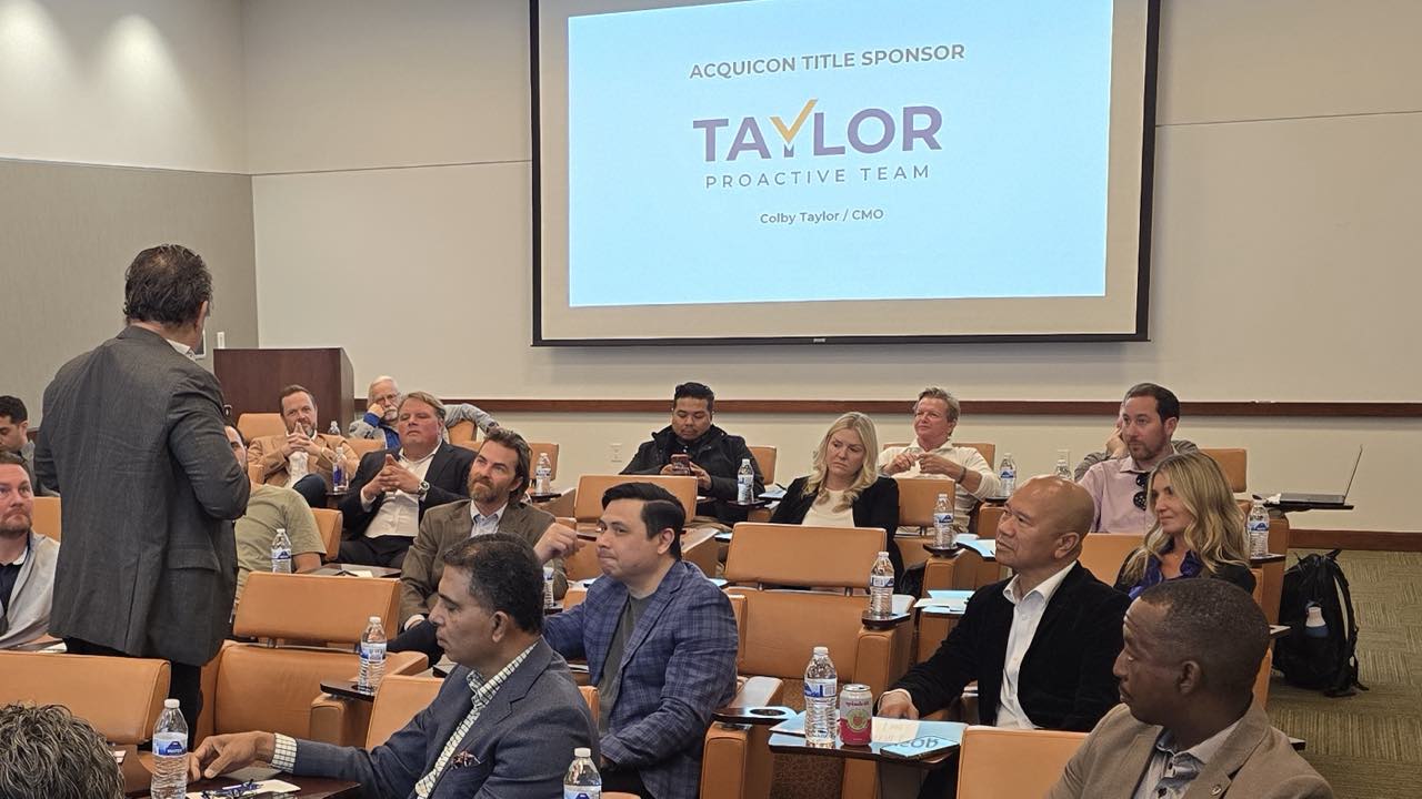Acquicon title sponsor slide showing the Taylor Proactive Team logo, with Colby Taylor presenting to a full room