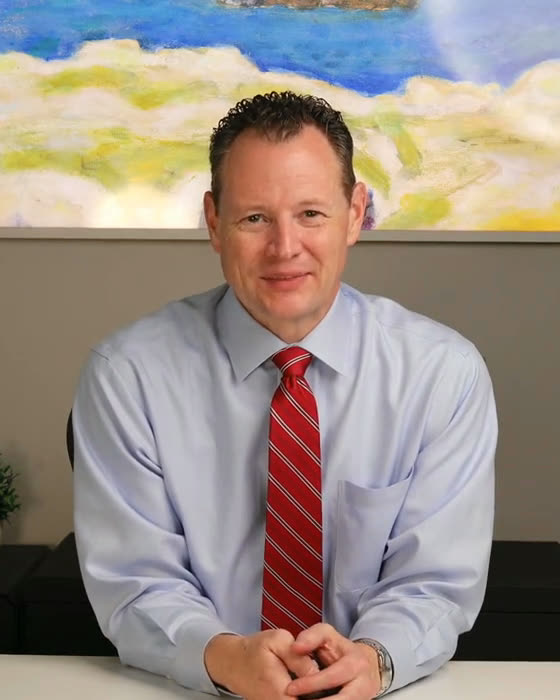 Merrill Taylor, CPA, smiling at his desk in the Taylor Proactive Team office.